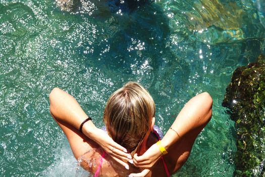 Beautiful blonde woman in the tropical pool. The enjoyment of summer vacation