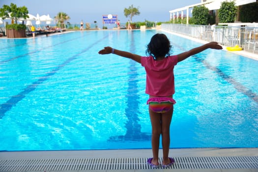 Little girl at the hotel pool. The enjoyment of summer vacation. Very happy