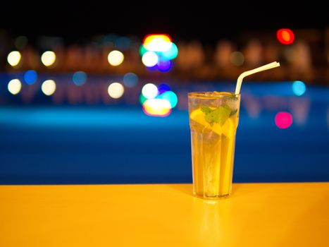 Enjoying cocktail by the pool at night