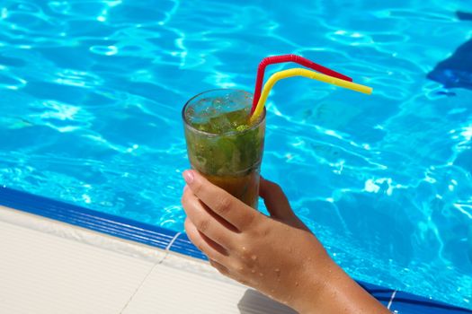 enjoying fresh lemon and mint mojito cocktail by the pool