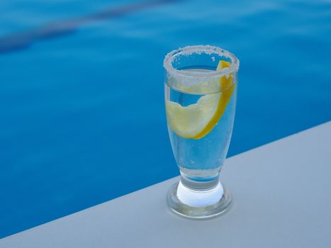 fresh lemon and salted tequila shot by the pool