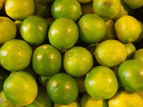 green lime close - up fruit background. stack of lemon