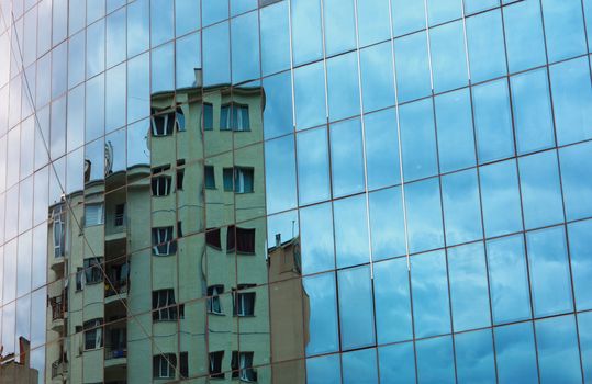 buildings reflected in windows.new structure against old structure