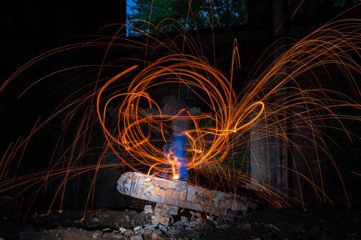 Drawing light at night in an old abandoned building, splashes of light and sparks. Freezelight