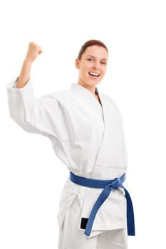 A portrait of a beautiful young girl in a kimono with blue belt cheering after her victory, isolated on white background.