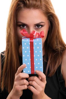 A portrait of a beautiful young girl holding a gift, isolated on white background.