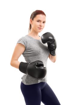 A portrait of a beautiful young girl with boxing gloves in a stance, isolated on white background.
