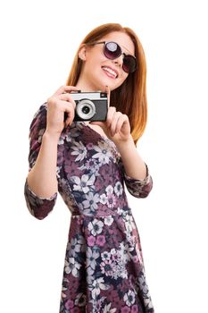 A portrait of a beautiful young girl taking a photo with a vintage camera, isolated on white background.
