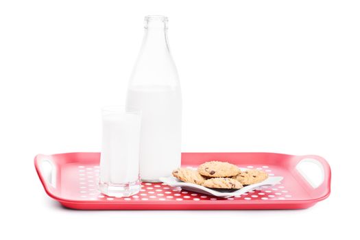 Close up shot of a bottle and glass of milk and chocolate chip cookies on a platter, isolated on white background.
