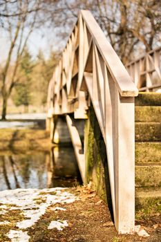 Crossing the bridge. Wooden bridge over a pond in the park.