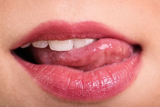 Close up shot of beautiful woman mouth with tongue out.