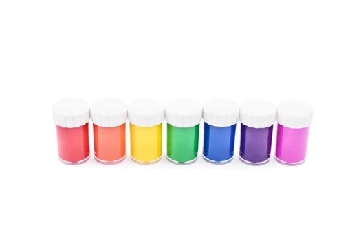 Color paint containers made of glass, ordered by the rainbow color spectrum, isolated on white background.