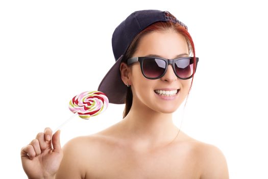 Cool beautiful girl with sunglasses and a snapback cap holding lollipop, isolated on a white background.
