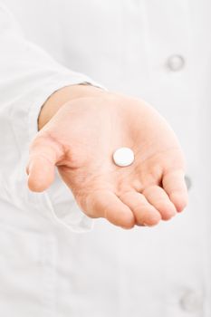 Have this and get better. Doctor's hand handing out a pill.