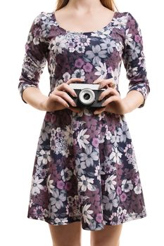 A close up shot of a girl in a colorful dress, hodling a vintage camera, isolated on white background.