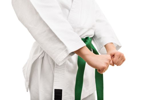 Combat readiness. Mid section of a young fighter in a kimono wth green belt, in a combat stance, isolated on white background.
