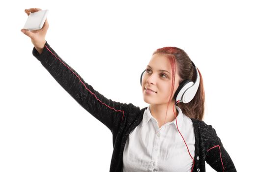 Young girl wearing headphones in a school uniform taking a selfie, isolated on white background.