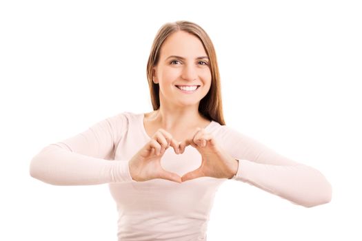 Beauty portrait of a smiling young girl making a heart shaped hand gesture, isolated on white background.