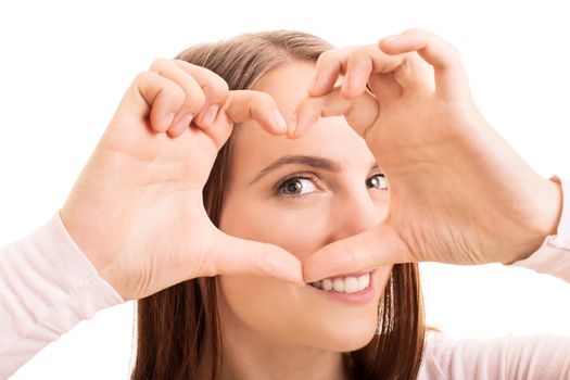 Close up beauty portrait of a smiling young girl looking through a heart shaped hands, isolated on white background.