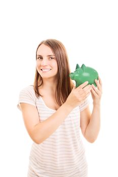 Beautiful young student girl holding a piggy bank, isolated on white background.