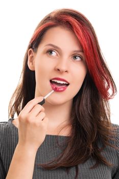 A portrait of a young beautiful girl putting lipstick, isolated on white background.