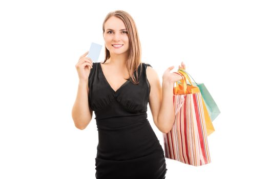 A portrait of an elegant beautiful young woman holding shopping bags and a card, isolated on white background.
