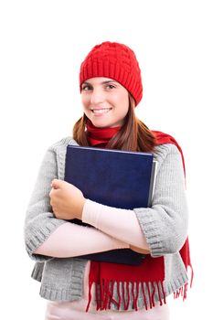 Portrait of a beautiful smiling female student in winter clothes holding a book, isolated on white background. I’m ready for winter exam season.