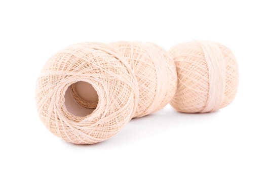 Close up shot of three aligned spools of embroidery threads, isolated on white background.
