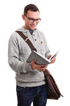 Smiling  handsome male student with glasses and a shoulder bag holding a book, isolated on white background. 