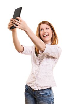 A portrait of a young beautiful girl taking a selfie with her tablet, isolated on white background.