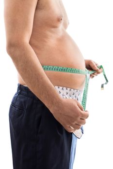 Close up of a young male with weight problems, measuring his big stomach with a measuring tape, isolated on white background.