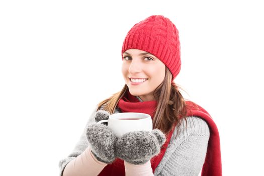 Beautiful smiling girl in winter clothes holding a cup of warm drink, isolated on white background.