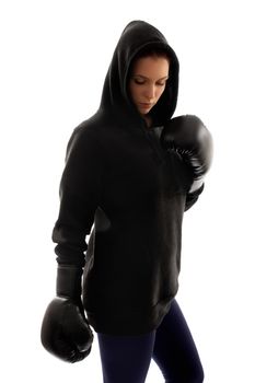 Young beautiful female boxer dressed in black looking down, with a dramatic light, isolated on a white background.