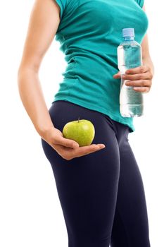 Healthy lifestyle's the key for fit figure. Fit girl holding a bottle of water and an apple, isolated on white background.