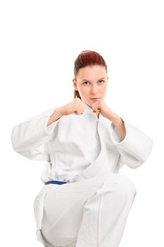A portrait of a beautiful young beautiful girl in a kimono with blue belt, in a combat stance preparing for a kick, isolated on white background.