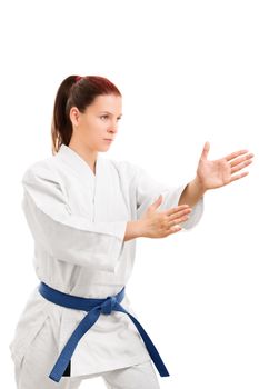 A portrait of a young girl in a kimono with blue belt in a fighting stance, isolated on white background.