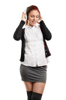 Portrait of a young beautiful woman enjoying music on her headphones, isolated on a white background.