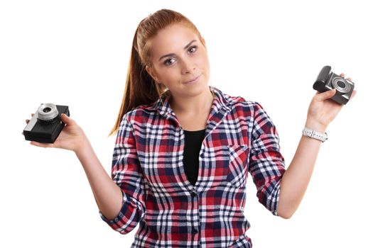 Young beautiful woman dressed in plaid shirt holding vintage and modern camera in each hand, isolated on a white background.