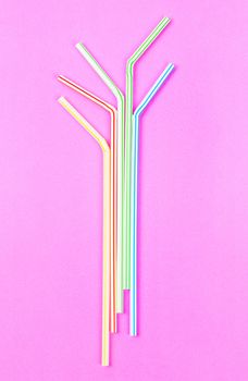 Colourful plastic straws tube for drink water on pink background.