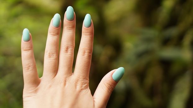 Close up of explorer female hand in green rainy forest. Survival travel, lifestyle concept.