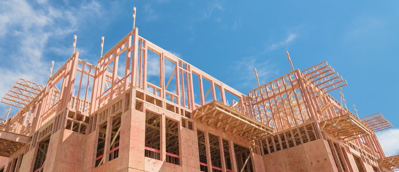 Panorama view low angle view of modern condominium building with large patio under construction near North Dallas, Texas. Wooden house with timber framing, truss, joist, beam close-up cloud blue sky