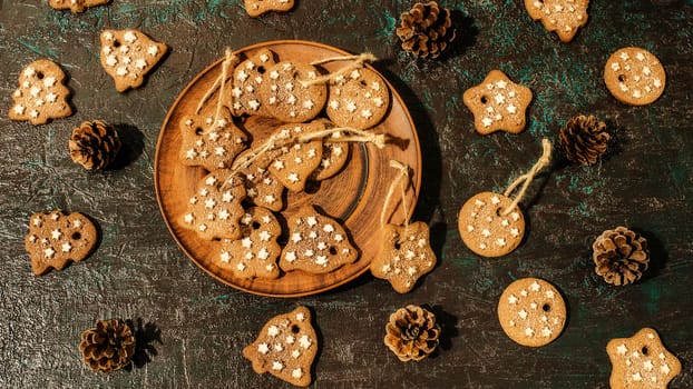 Christmas theme with cookies, spruce cones on a dark background. Flat lay