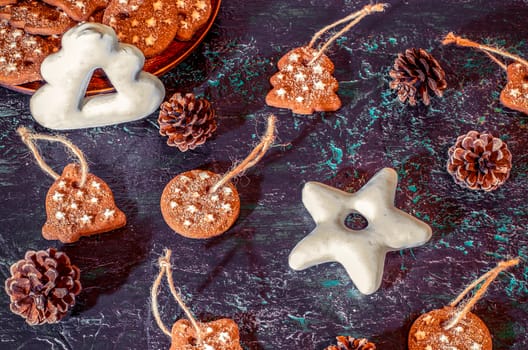 Christmas theme with cookies, spruce cones on a dark background. Flat lay