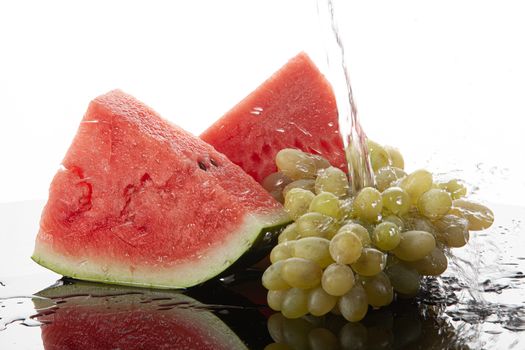 Pieces of watermelon and bunch of grape on a glass
