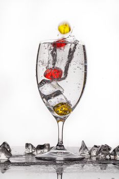 Dices, crystals of ice and glass of water ona glass backround