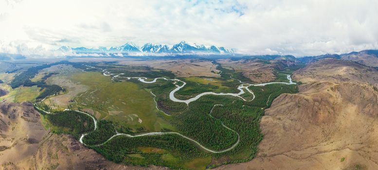 Kurai steppe and Chuya river on North-Chui ridge background. Altai mountains, Russia. Aerial drone panoramic picture.