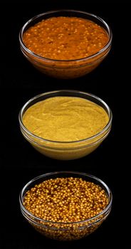 Set of various types of mustard on black background