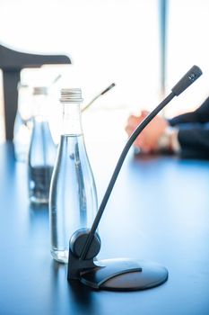 Conference room table for business meeting with microphones and bottles of water