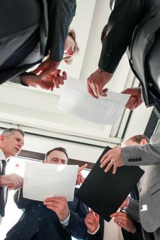 Group of business people work with documents at meeting standing in office