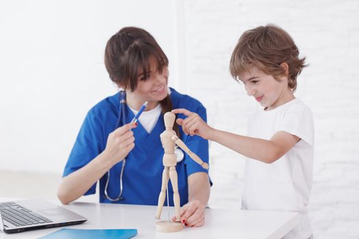 Doctor explain medicine to child using wooden doll